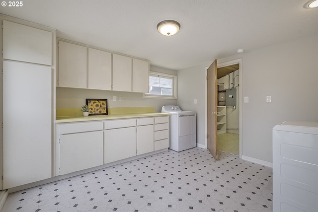 laundry area with electric panel, light flooring, baseboards, independent washer and dryer, and cabinet space