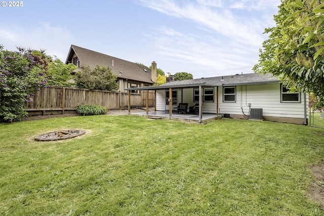 rear view of property with a fire pit, a patio, and central AC unit