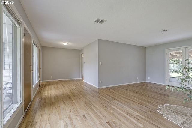 spare room with light wood-style floors and baseboards
