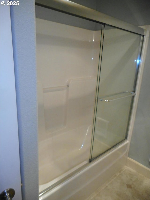 bathroom with baseboards, bath / shower combo with glass door, and tile patterned floors