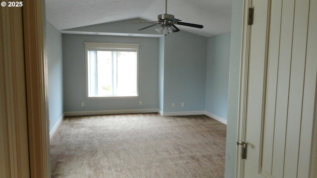 carpeted spare room featuring baseboards, ceiling fan, and lofted ceiling