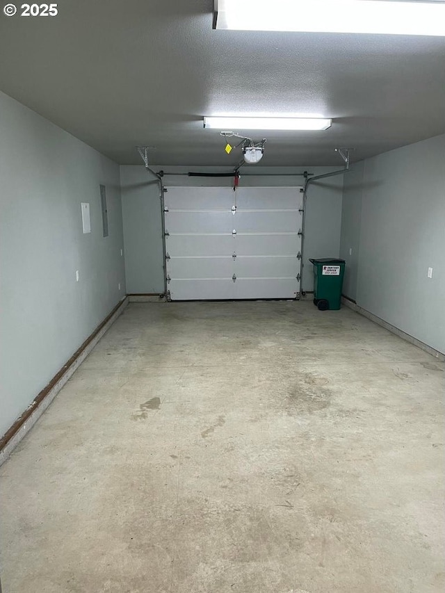 garage with baseboards and a garage door opener