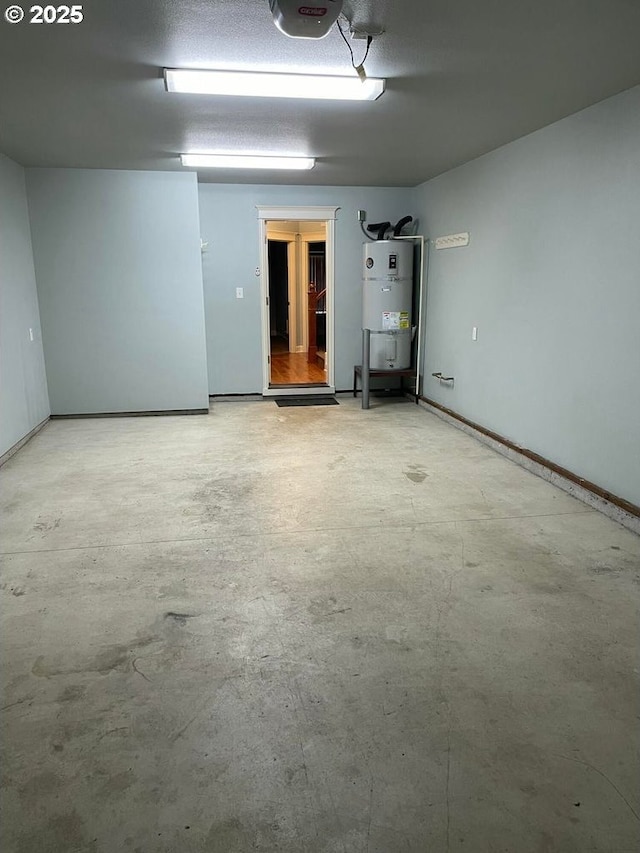 garage with baseboards, strapped water heater, and a garage door opener