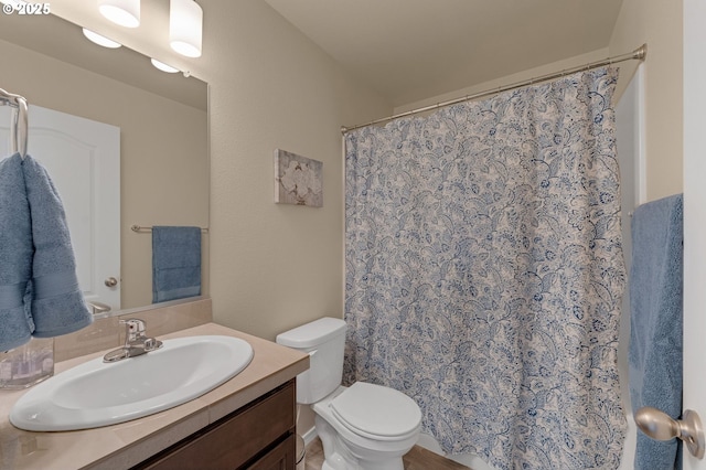 bathroom with curtained shower, vanity, and toilet