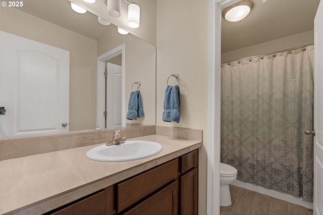 full bathroom featuring curtained shower, vanity, toilet, and wood finished floors