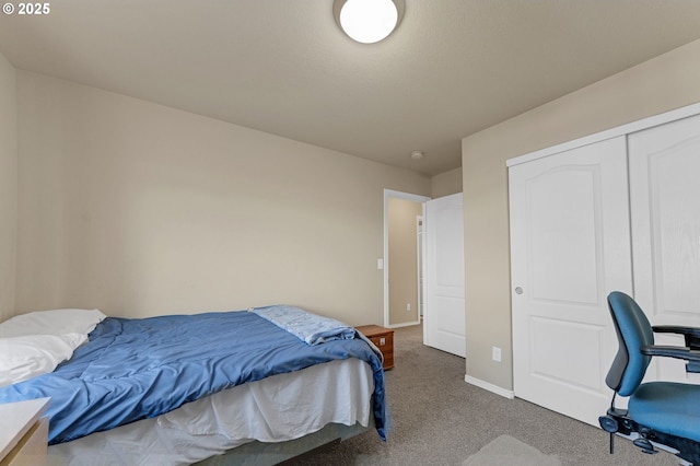 carpeted bedroom featuring a closet and baseboards