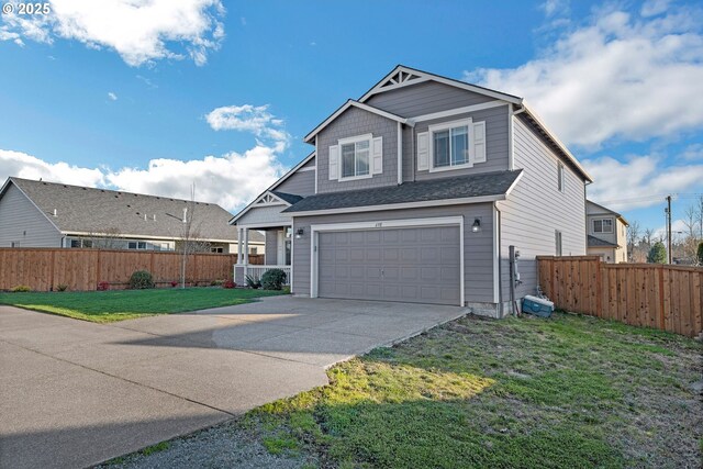 traditional-style home featuring driveway, an attached garage, fence, and a front lawn