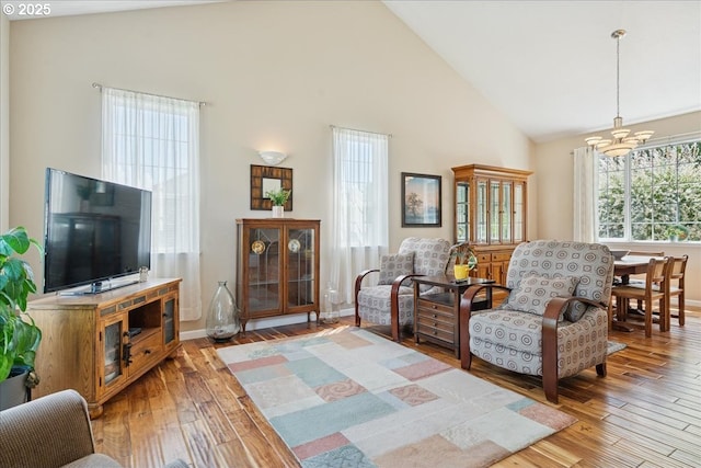 5277 Landon St, Salem, OR 97306 - living room featuring high vaulted ceiling, a chandelier, light wood-style flooring, and baseboards