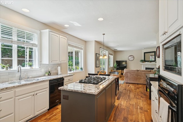 5277 Landon St, Salem, OR 97306 - kitchen featuring black appliances, a sink, a kitchen island, white cabinets, and backsplash