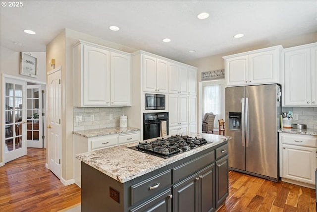 5277 Landon St, Salem, OR 97306 - kitchen with black appliances, white cabinets, french doors, backsplash, and light wood-style floors