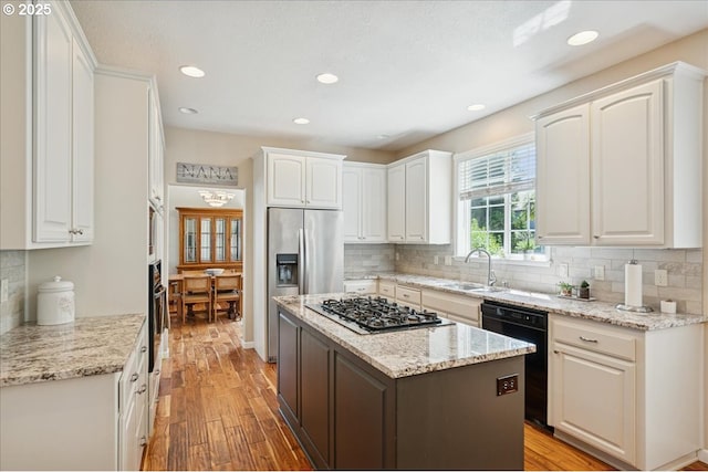 5277 Landon St, Salem, OR 97306 - kitchen with black appliances, a sink, white cabinets, light wood-type flooring, and recessed lighting