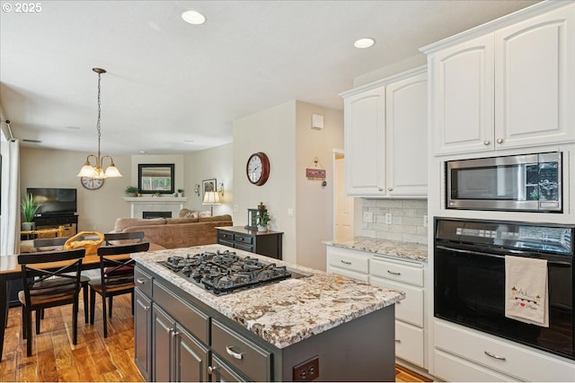 5277 Landon St, Salem, OR 97306 - kitchen with black appliances, gray cabinetry, a kitchen island, open floor plan, and white cabinets