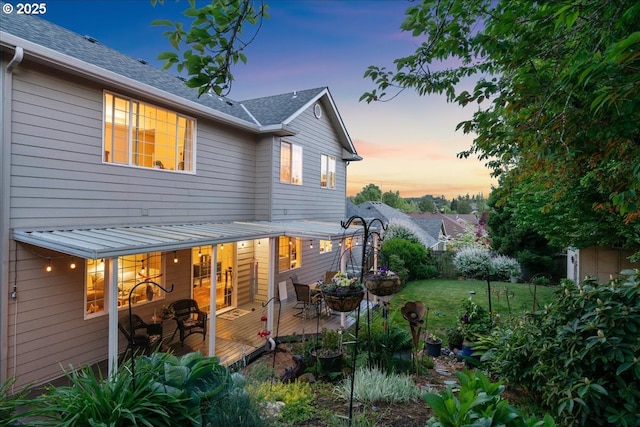 5277 Landon St, Salem, OR 97306 - back of house at dusk featuring a lawn, a wooden deck, and outdoor dining space