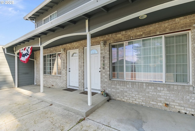 view of exterior entry with a patio area