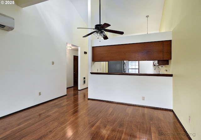 13775 SW Scholls Ferry Rd Unit 16, Beaverton, OR 97008 - unfurnished living room with an AC wall unit, a ceiling fan, wood finished floors, and a towering ceiling