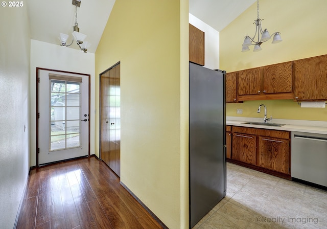13775 SW Scholls Ferry Rd Unit 16, Beaverton, OR 97008 - kitchen featuring stainless steel appliances, a chandelier, light countertops, brown cabinets, and high vaulted ceiling