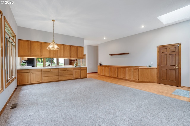 32680 SW Lake Point Ct, Wilsonville, OR 97070 - kitchen featuring decorative light fixtures, light countertops, recessed lighting, a skylight, and light wood-style floors
