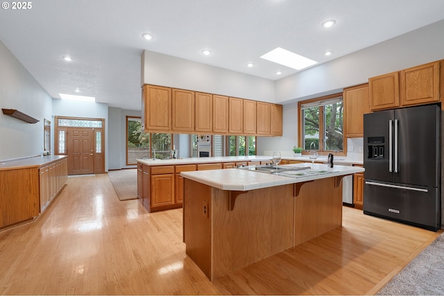 32680 SW Lake Point Ct, Wilsonville, OR 97070 - kitchen featuring high end refrigerator, light wood-type flooring, a center island with sink, recessed lighting, and tile countertops