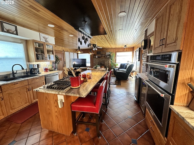 kitchen with dishwasher, a center island, wood ceiling, sink, and a breakfast bar