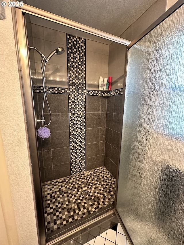 bathroom with a textured ceiling, tile patterned floors, and an enclosed shower