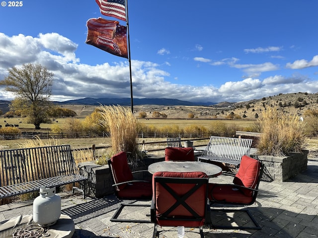 view of patio / terrace with a mountain view and a rural view