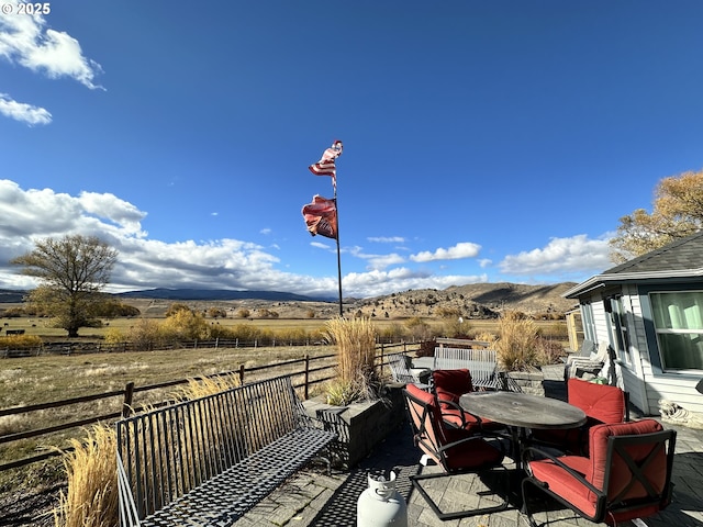 deck featuring a mountain view, a patio area, and a rural view