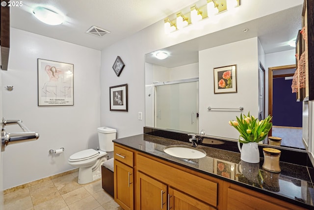 bathroom with a stall shower, baseboards, visible vents, toilet, and vanity