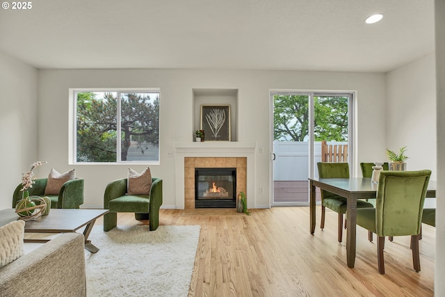 697 NW Rubus Ln, Hillsboro, OR 97124 - living area with healthy amount of natural light, recessed lighting, light wood-style floors, a tiled fireplace, and baseboards
