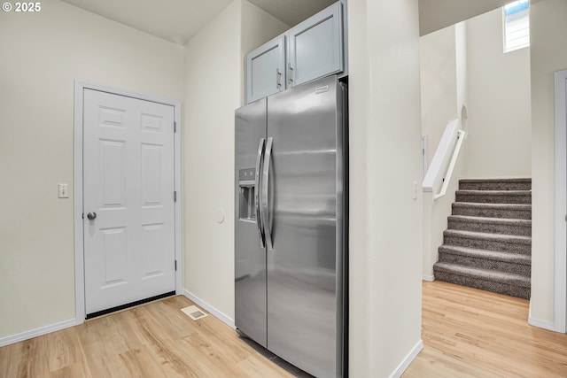 697 NW Rubus Ln, Hillsboro, OR 97124 - kitchen with stainless steel refrigerator with ice dispenser, light wood finished floors, and baseboards