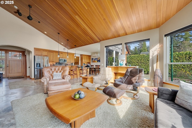 living area featuring arched walkways, high vaulted ceiling, and wood ceiling