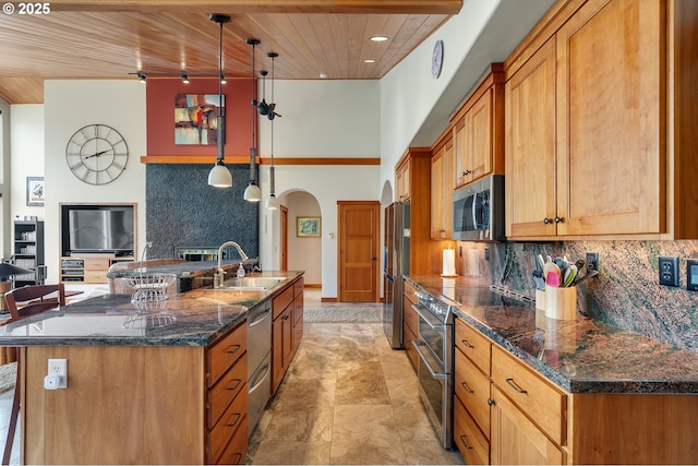 kitchen featuring a sink, stainless steel appliances, arched walkways, decorative backsplash, and wood ceiling