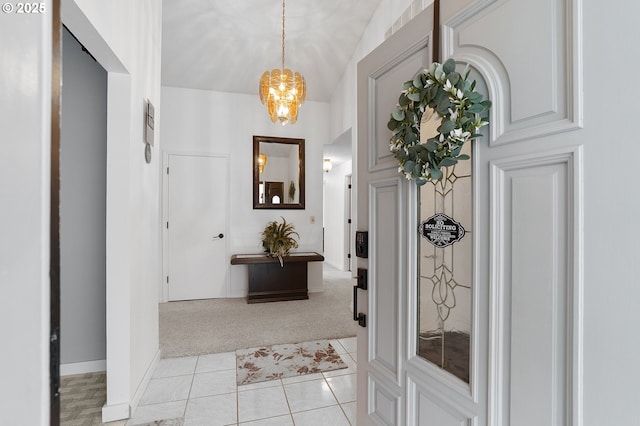 foyer with light tile patterned floors, a notable chandelier, light colored carpet, and baseboards