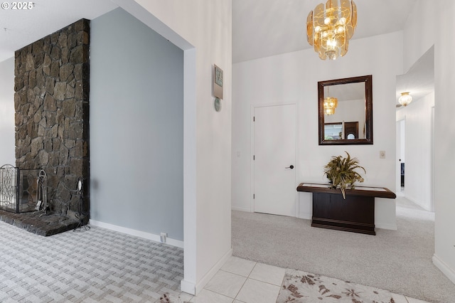 hall featuring tile patterned flooring, a chandelier, baseboards, and carpet