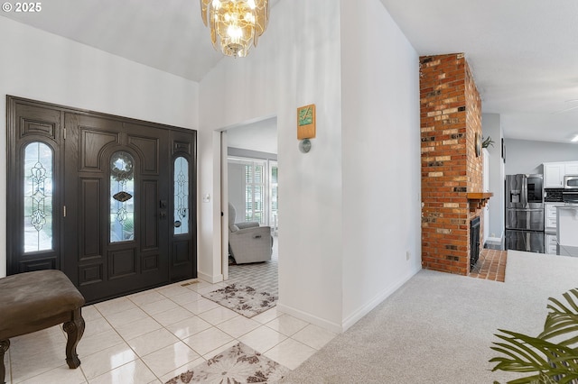 foyer entrance with light tile patterned floors, a notable chandelier, light carpet, and baseboards