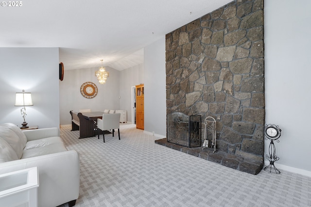 living room with a notable chandelier, lofted ceiling, a fireplace, carpet flooring, and baseboards