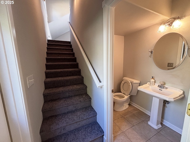 staircase featuring tile patterned flooring and baseboards