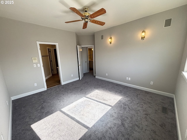 unfurnished bedroom featuring dark carpet, visible vents, and baseboards