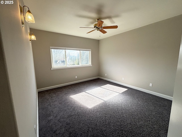 spare room featuring dark carpet, a ceiling fan, and baseboards