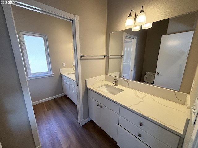 bathroom with vanity, baseboards, and wood finished floors