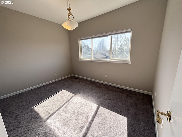 unfurnished room with dark colored carpet and baseboards