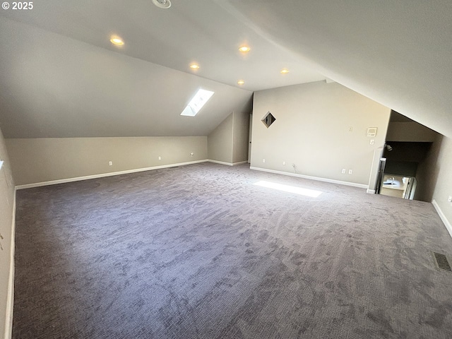 additional living space featuring vaulted ceiling with skylight, recessed lighting, carpet floors, visible vents, and baseboards