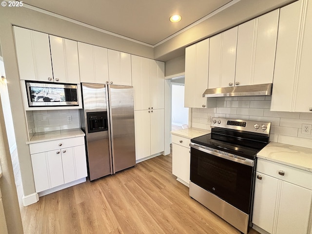 kitchen featuring under cabinet range hood, white cabinets, light countertops, appliances with stainless steel finishes, and light wood finished floors