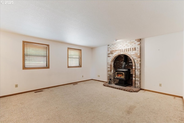 20916 SW Siletz Ct, Tualatin, OR 97062 - unfurnished living room with a wood stove, carpet flooring, and a textured ceiling
