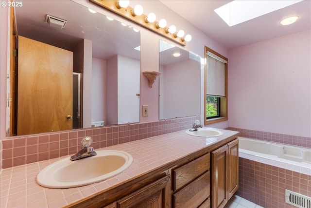 20916 SW Siletz Ct, Tualatin, OR 97062 - bathroom featuring a skylight, double vanity, a garden tub, tile patterned flooring, and a shower with door