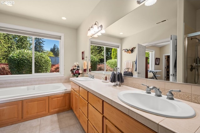 bathroom with a bath, visible vents, a sink, a stall shower, and double vanity