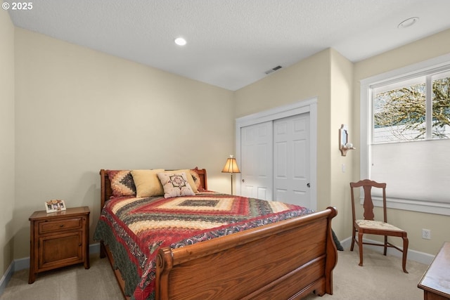 bedroom featuring a closet, visible vents, recessed lighting, light carpet, and baseboards