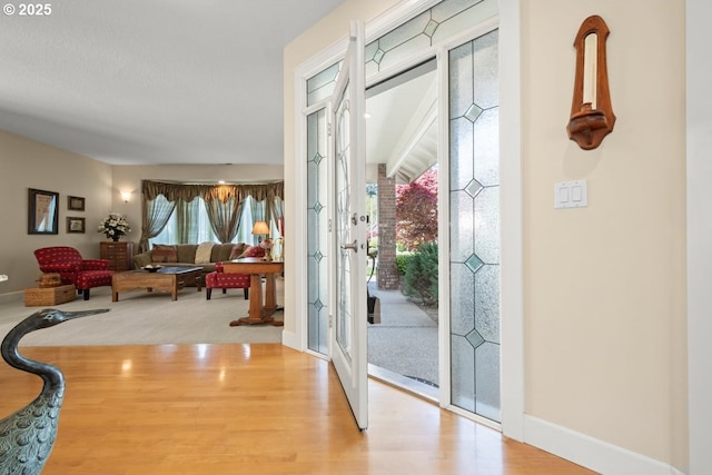 entryway featuring french doors, baseboards, and wood finished floors