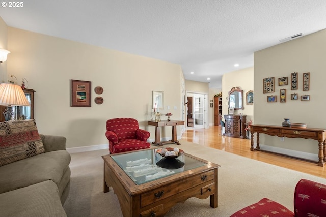 carpeted living area featuring wood finished floors, baseboards, visible vents, and recessed lighting