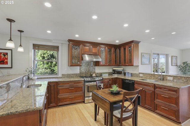 kitchen featuring appliances with stainless steel finishes, kitchen peninsula, decorative light fixtures, and sink