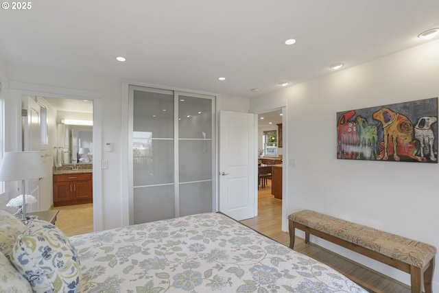 bedroom with light hardwood / wood-style flooring and connected bathroom